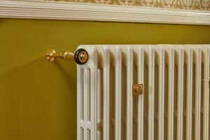 Cast iron radiator in Farrow and Ball paint with unlacquered brass TRV valves