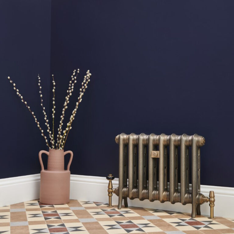 Lifestyle photo of school style Emmeline cast iron radiator in beaten brass.