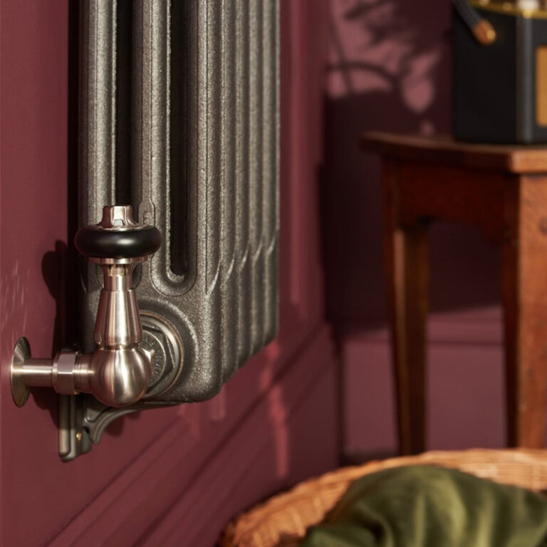 Lifestyle photo of Mercury 3 Column cast iron radiator in black iron finish with Windsor valves.