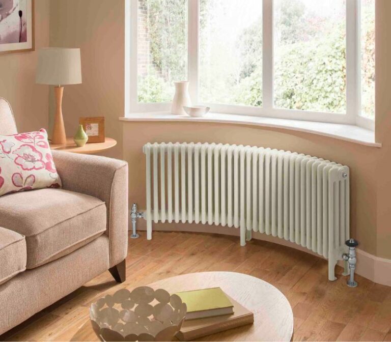 White, curved steel column radiator in a living room bay window