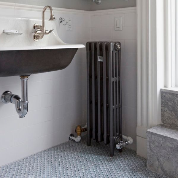 Lifestyle photo of mercury 4 column cast iron radiator in bathroom with mid grey sparkle finish