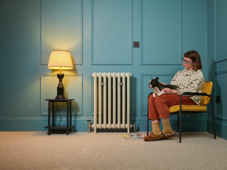 Lifestyle image of white Emmeline cast iron radiator in cosy living room with hydronic Windsor valves