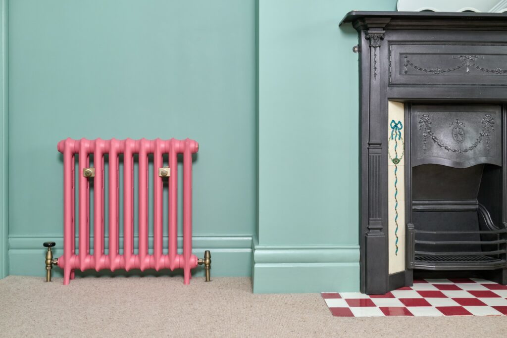 Castrads Emmeline cast iron radiator beside Edwardian fireplace